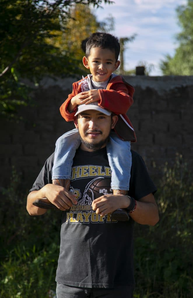 Man and Son on His Shoulders Staring at the Camera
