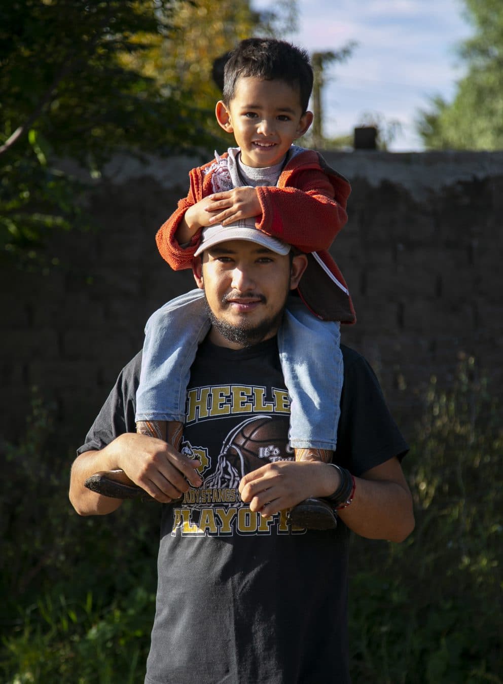Man and Son on His Shoulders Staring at the Camera